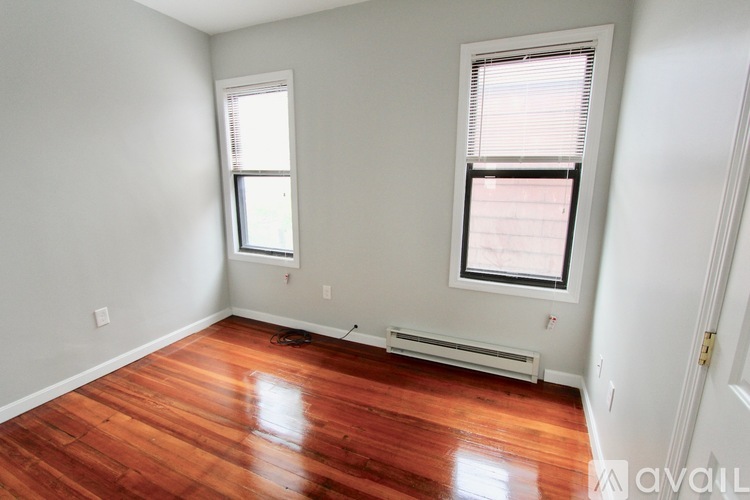 A room with wooden floors and two windows.