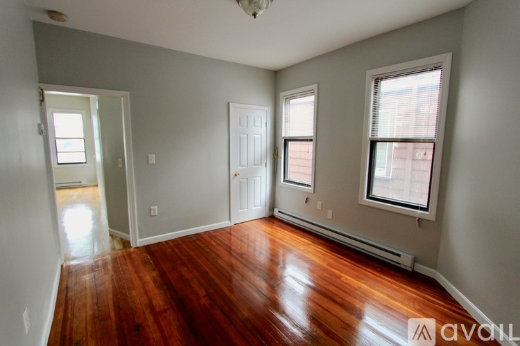 A room with wooden floors and two windows.