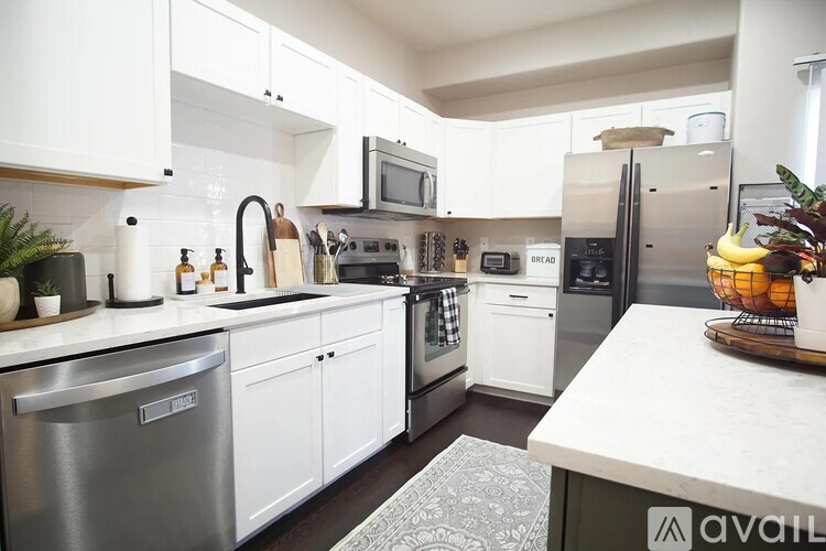 A kitchen with white cabinets and a stainless steel dishwasher.