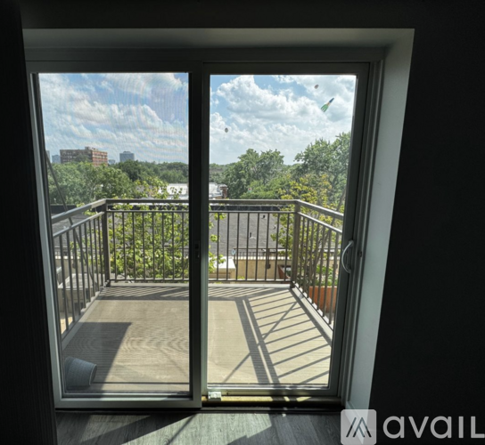 A balcony with a view of the city and trees.