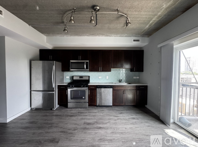A kitchen with dark wood cabinets and stainless steel appliances.