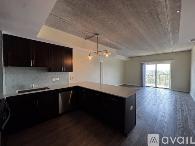 A kitchen with dark wood cabinets and a concrete ceiling.