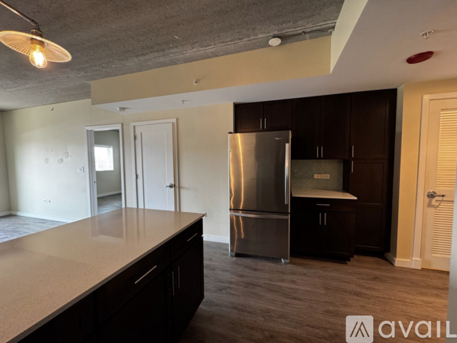 A kitchen with a refrigerator, cabinets, and a countertop.