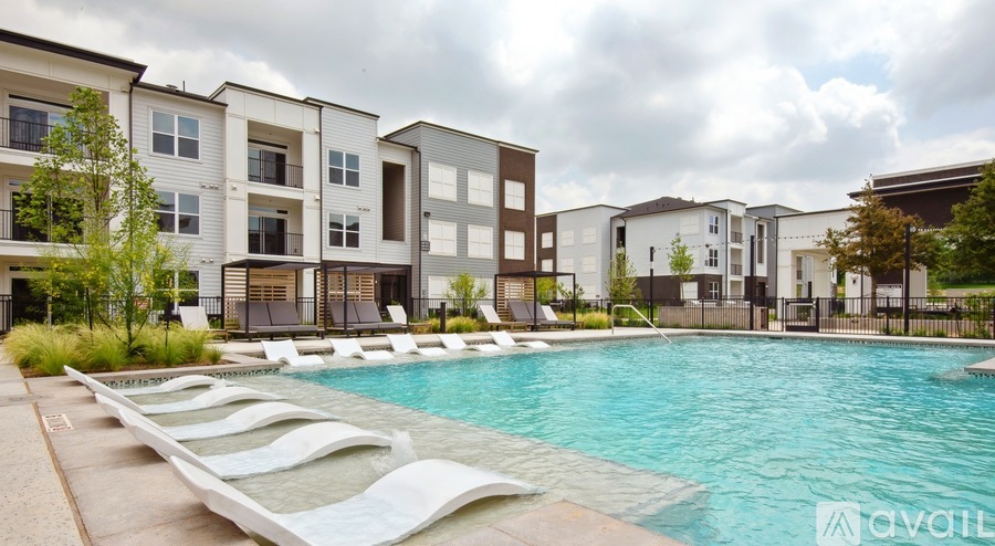 A swimming pool surrounded by lounge chairs and apartment buildings.