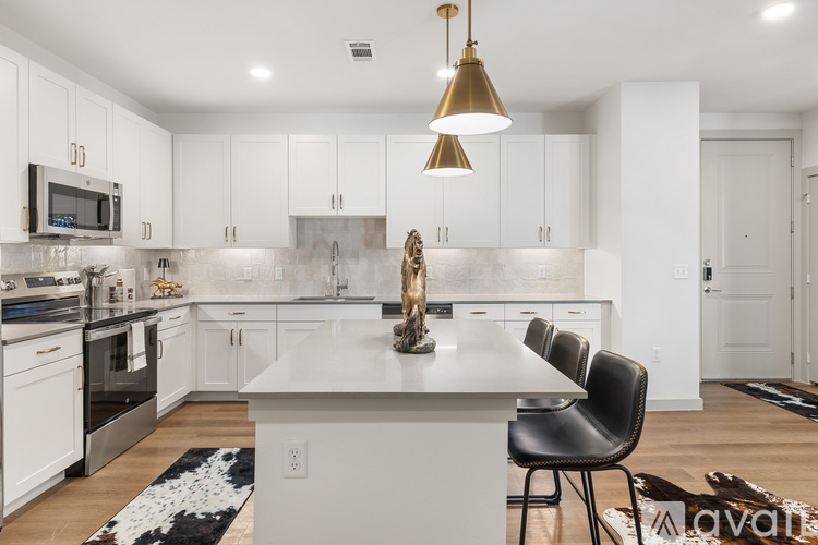 A modern kitchen with white cabinets and a large island.