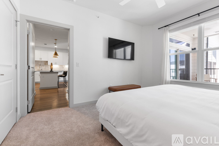 A bedroom with a large bed and a television mounted on the wall.