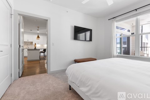 A bedroom with a large bed and a television mounted on the wall.