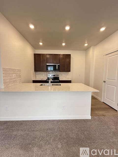 A kitchen with white countertops and brown cabinets.