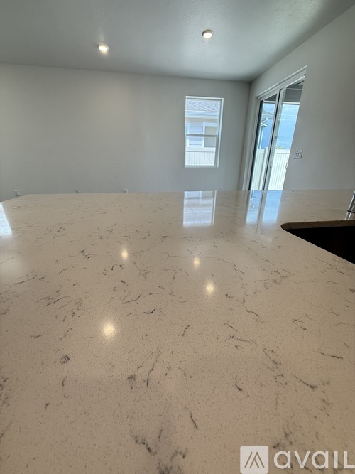 A large, polished marble table occupies the center of a spacious room.
