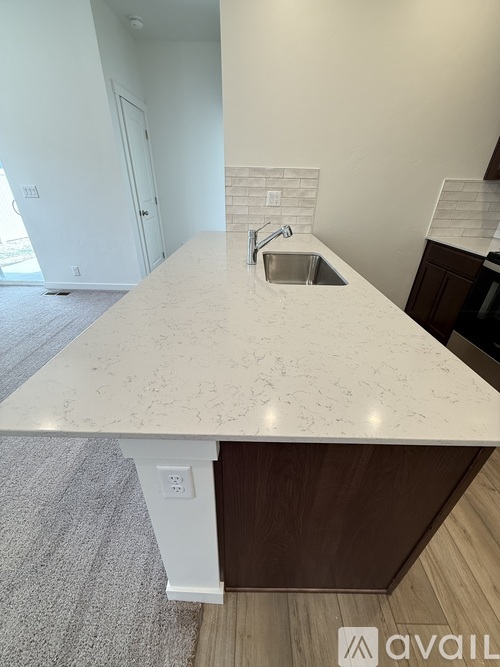 A kitchen island with a sink in the middle.