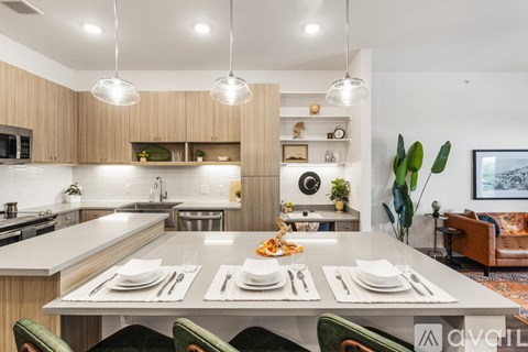 A modern kitchen with a dining table set for two.