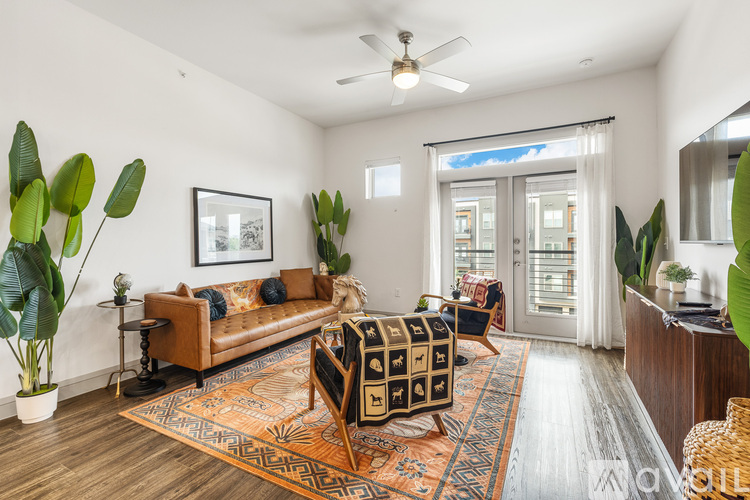 A living room with a brown couch and a rug.