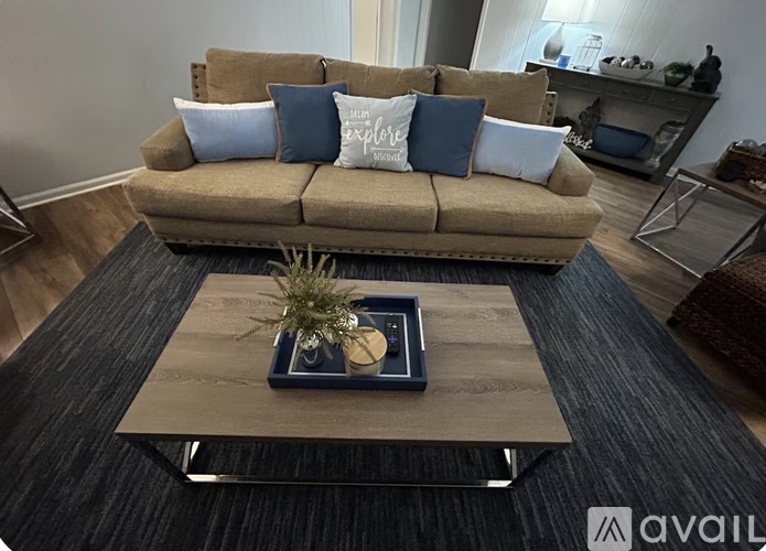 A living room with a brown couch and a wooden coffee table.