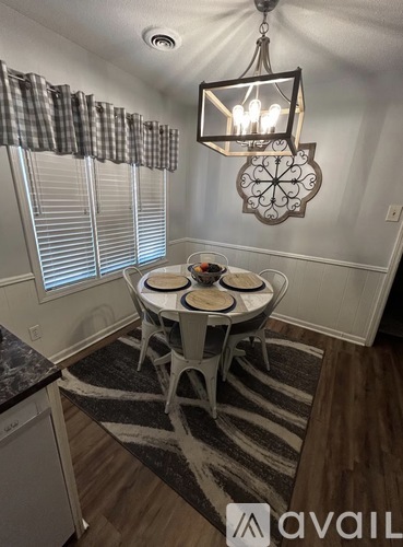A dining room with a round table and chairs.
