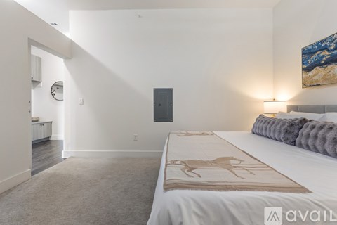 A bedroom with a large bed and a painting on the wall.