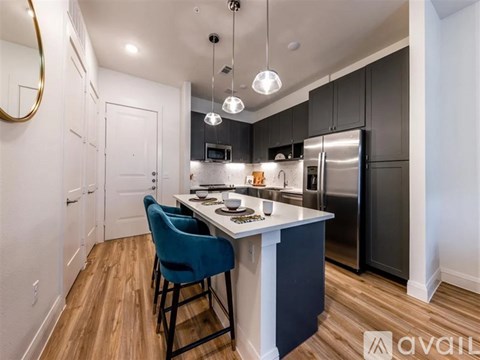 A kitchen with a blue chair and a white island.