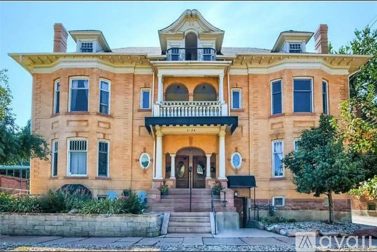 A large, two-story house with a balcony and a front porch.