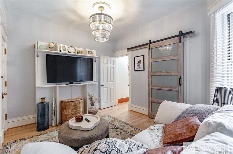 A living room with a white couch and a wooden door.