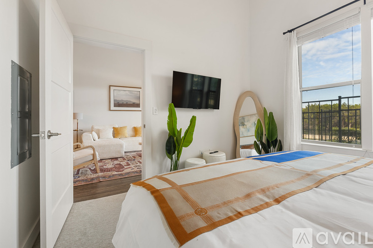 A bedroom with a large bed and a flat screen TV mounted on the wall.