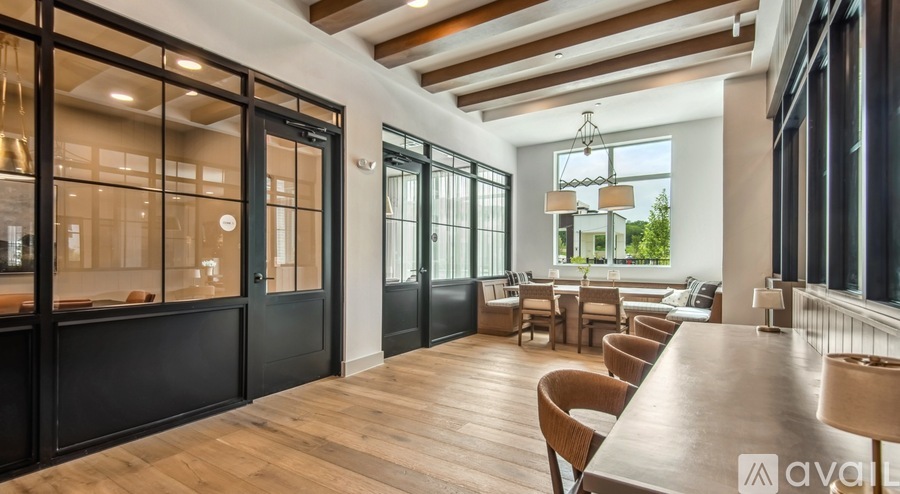 A modern dining room with a long wooden table and chairs.