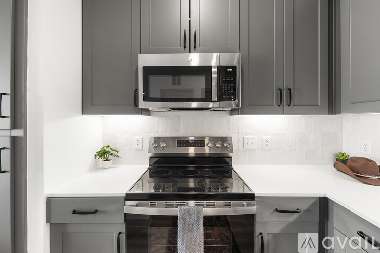 A modern kitchen with a stove top oven and microwave above it.