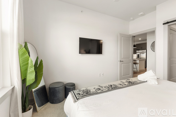 A bedroom with a large bed and a flat screen TV mounted on the wall.