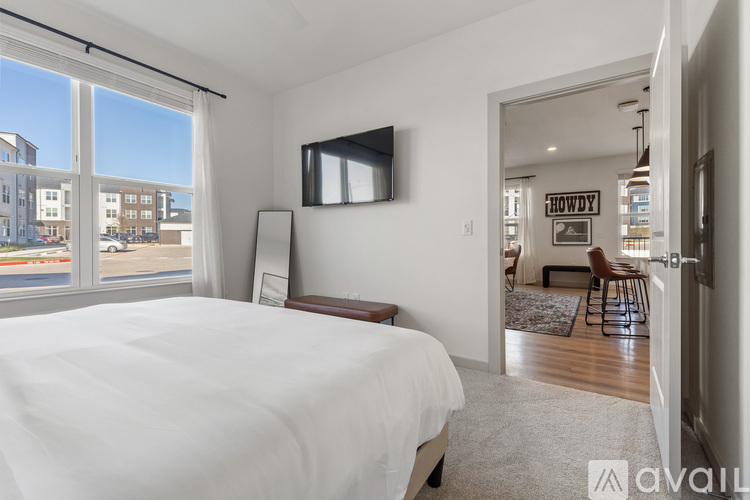 A bedroom with a large bed and a flat screen TV mounted on the wall.