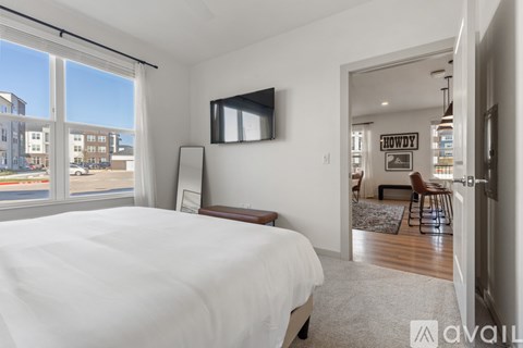 A bedroom with a large bed and a flat screen TV mounted on the wall.