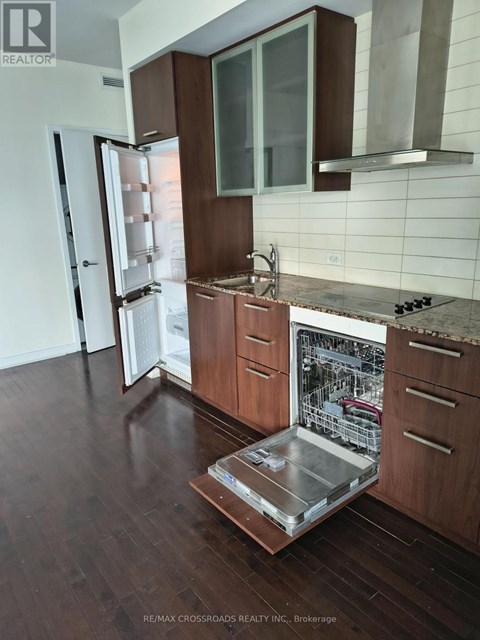 A modern kitchen with wooden cabinets and a glass table.