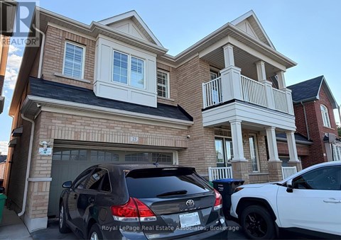 Two cars are parked in front of a two-story house.