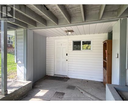 A white door is on the left side of a porch.