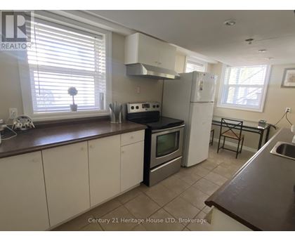 A kitchen with white cabinets and a brown countertop.