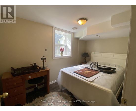 A bedroom with a bed, desk, and chair.