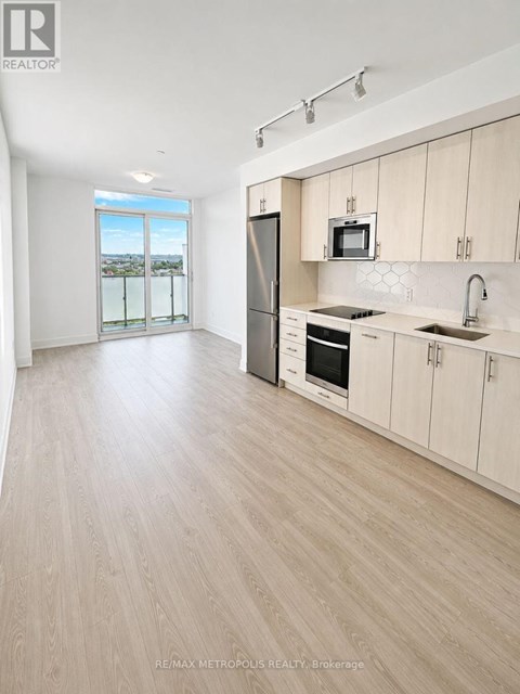 A modern kitchen with wooden floors and white walls.