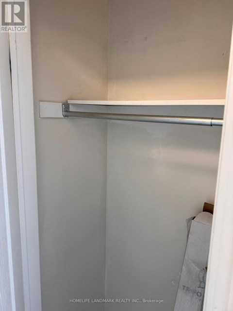 A white closet with a metal rod hanging from the top.