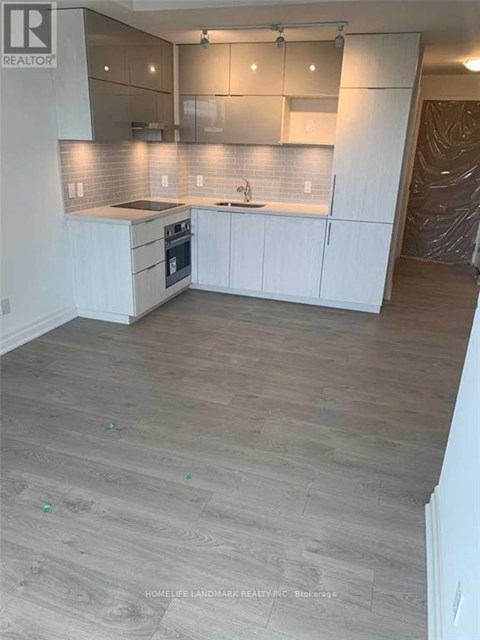 A kitchen with white cabinets and a wooden floor.
