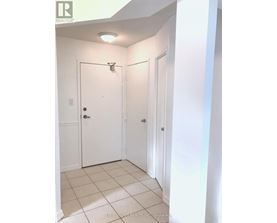A white door with a silver handle is in a white room.