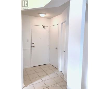 A white door with a silver handle is in a white room.