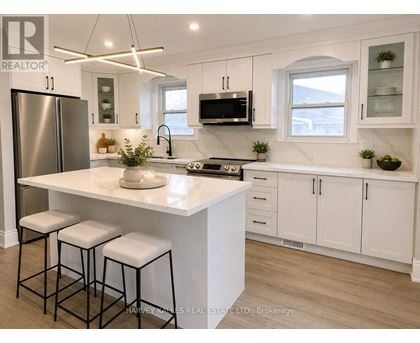 A modern kitchen with white cabinets and a central island.