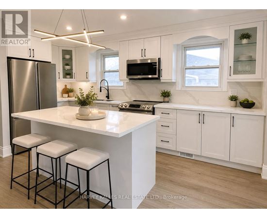 A modern kitchen with white cabinets and a central island.