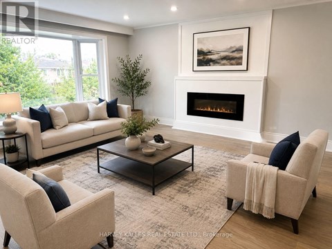 A living room with a fireplace and a painting on the wall.