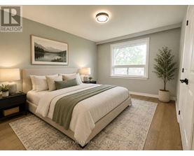 A bedroom with a large bed and a painting on the wall.