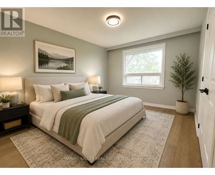 A bedroom with a large bed and a painting on the wall.