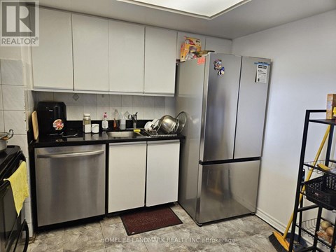 A kitchen with a refrigerator, sink, and stove.