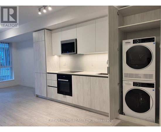A modern kitchen with white cabinets and a black oven.