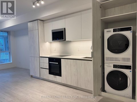 A modern kitchen with white cabinets and a black oven.