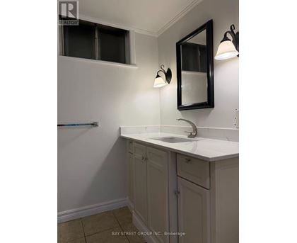 A bathroom with a sink, mirror, and light fixtures.