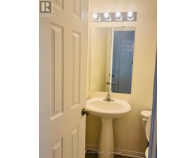 A white pedestal sink in a small bathroom.