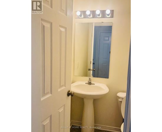 A white pedestal sink in a small bathroom.