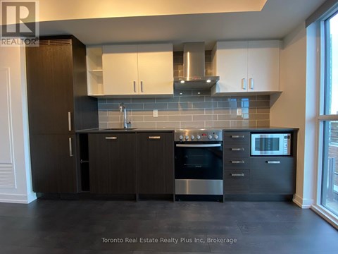 A modern kitchen with dark wood cabinets and stainless steel appliances.